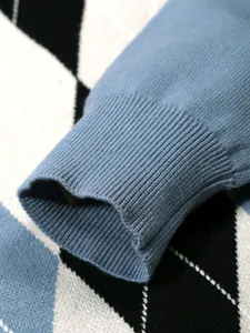 Detailed close-up showing the ribbed cuff texture of a blue argyle jacquard knitted sweater