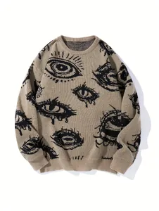 Detailansicht eines khakifarbenen Strickpullovers mit schwarzem Augenmuster Motiv.