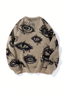 Detailansicht eines beigen Oversized-Strickpullovers mit schwarzem, grafischem Augenmuster.