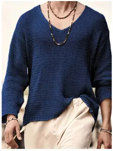 Gros plan sur la maille ajourée bleu marine d'un pull col en V élégant pour homme