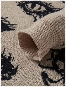 Makroaufnahme der Stricktextur und des Augenmusters auf dem beigen Pulloverärmel