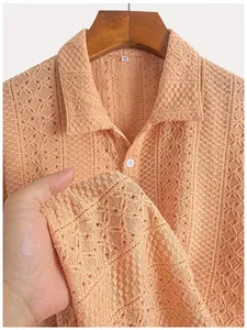 Close-up of apricot textured knit polo shirt showing intricate geometric hollow pattern.