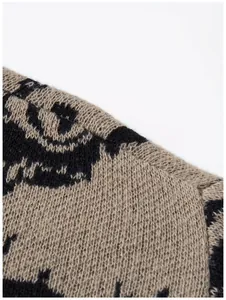 Nahaufnahme des Strickpullover-Stoffs mit beige-schwarzem Jacquard-Augenmuster-Struktur
