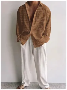 Dettaglio camicia casual da uomo marrone a maniche lunghe testurizzata con pantaloni