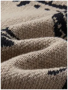 Detaillierte Nahaufnahme der weichen Textur und des schwarzen Jacquardmusters des Strickpullovers