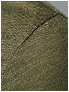 Macro shot of olive green slub jersey fabric and durable seam on a men's casual T-shirt.