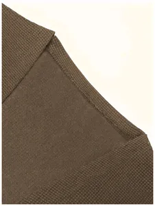 Gros plan sur la couture intérieure et la texture tricotée d'un gilet marron élégant
