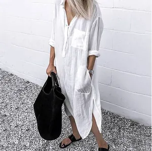 Detail view of white linen-style maxi shirt dress featuring side slits and front pocket