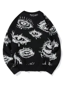 Nahaufnahme eines schwarzen Oversize-Strickpullovers mit weißem Augenmuster-Detail.