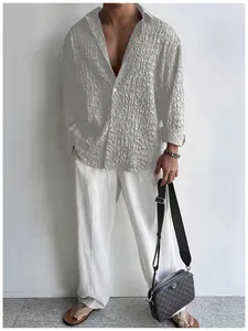 Dettaglio di camicia grigia da uomo con trama stropicciata abbinata a pantaloni bianchi chic