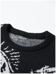 Nahaufnahme des gerippten Ausschnitts und des Augenmusters auf einem schwarzen Strickpullover.
