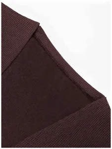 Gros plan sur la texture du tricot marron café et la couture d'un gilet.