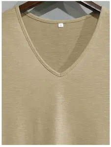 Détail du col en V et de la texture du tissu flammé respirant du t-shirt beige.
