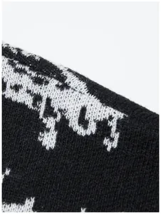 Detailaufnahme des schwarz-weißen Jacquard-Strickmusters eines dunklen Pullovers