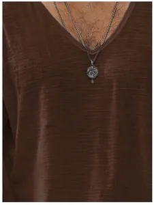 Détail du t-shirt marron à col en V pour hommes montrant la texture du tissu léger.