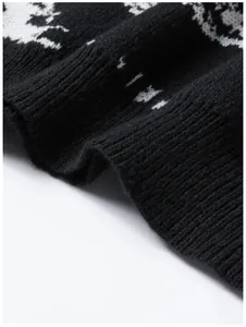 Nahaufnahme der dicken Strickstruktur eines schwarz-weißen Pullovers mit Augenmuster