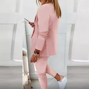 Stylish pink casual women's blazer and tailored pants suit for professional look