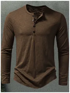 Detail of brown men's long sleeve Henley t-shirt with textured fabric and button neck