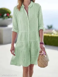 Elegant green and white striped tiered shirt dress for women in bright outdoor light