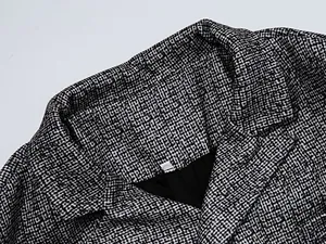 Close-up detail of a men's blazer showing the micro-check fabric and lapel structure