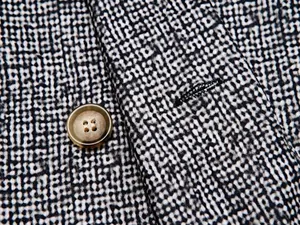 Close-up of textured black and white patterned fabric on a men's casual blazer jacket