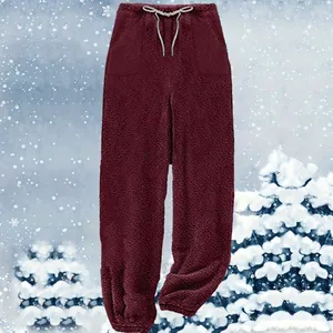 Detailed texture of burgundy plush fleece lounge pants against a snowy winter background