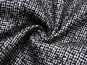 Macro detail showing the high-quality black and white textured fabric of men's blazer