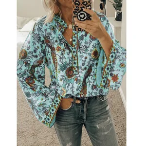 Vue détaillée d'une blouse bohème bleu clair à motif paon avec col en V et boutons