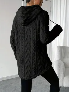 Vista detallada de una sudadera con capucha negra con intrincado patrón de punto jacquard.