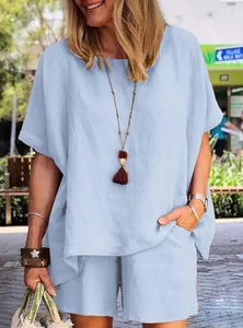 Loose-fitting light blue linen blend two-piece set shown on model in outdoor setting