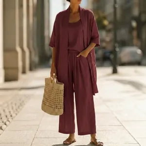 Detail showing a burgundy three-piece linen-style set in a sunny urban street setting
