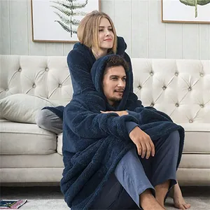Cozy oversized navy sherpa hoodie blanket for couples relaxing on a sofa.