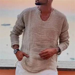 Détail rapproché des bords effilochés sur une chemise ample en lin à col en V