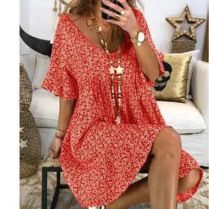 Detalle de un vestido rojo holgado con estampado de flores y mangas acampanadas.