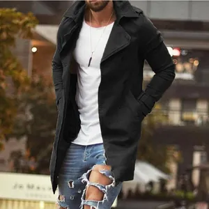 Stylish men's mid-length black trench coat in a casual urban street style setting.
