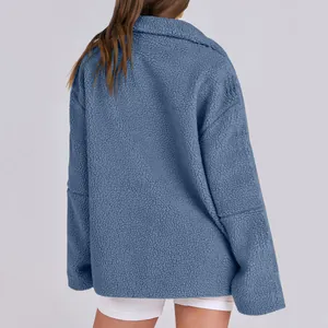 Vista posteriore di una calda giacca in pile sherpa blu da donna con collo alto alla moda.