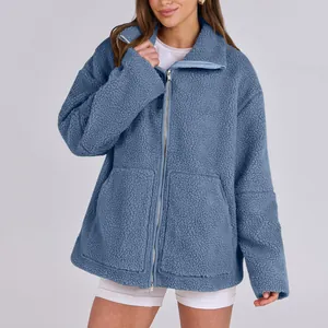 Giacca in pile Sherpa blu da donna con collo alto e tasche indossata da modella.