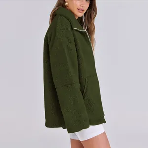 Dettaglio della giacca in pile sherpa verde oliva con collo alto e chiusura a zip.