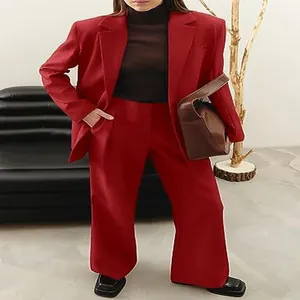 Detail view of a woman wearing a red professional blazer and wide-leg trouser suit set