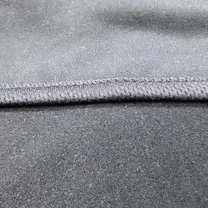 Makroansicht der grauen, feuchtigkeitstransportierenden Fleece-Stofftextur und Nähte.