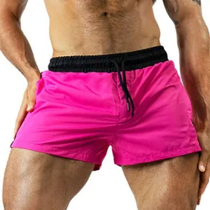 Macro view of vibrant pink men's athletic shorts featuring a black elastic waistband.