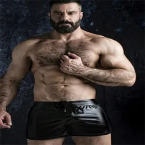 Macro view of men's black high-shine fitness shorts on a muscular model for gym wear
