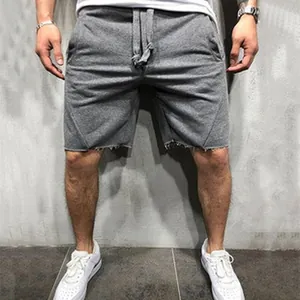 Detail view of grey drawstring men's athletic shorts with raw-cut hems and side pockets.