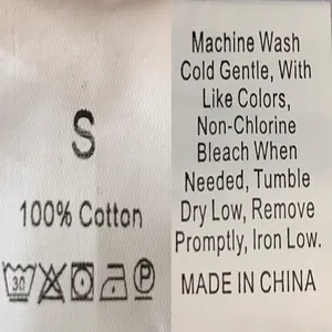 Detail view of clothing care label showing 100% cotton material and wash instructions