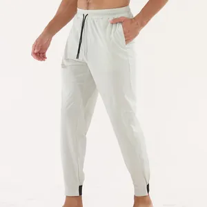 Détail du pantalon de sport beige pour homme avec cordon de serrage et poignets noirs