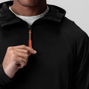 Nahaufnahme eines schwarzen Half-Zip-Hoodies mit leuchtend orangem Reißverschluss