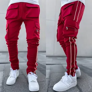 Detail view of red cargo pants for men featuring reflective side stripes and multiple pockets.