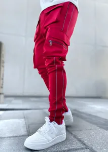 Detail view of red men's cargo pants featuring multiple utility pockets and reflective stripes