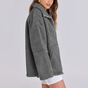 Vista laterale dettagliata di una giacca teddy fleece grigia oversize per donna