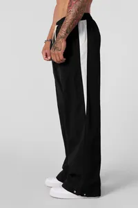 Side view of men's loose casual trousers featuring white side stripes and breathable fabric